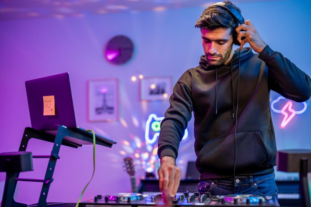 Caucasian man artist DJ mixing and scratching music mixer controller.