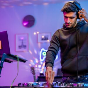 Caucasian man artist DJ mixing and scratching music mixer controller.