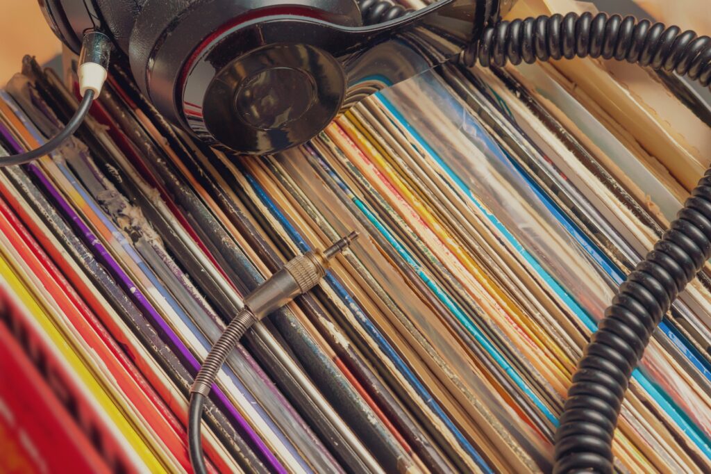 dark headphones lay on stack of retro vinyl records b