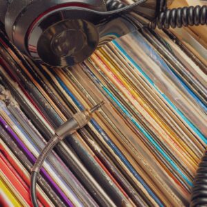 dark headphones lay on stack of retro vinyl records b
