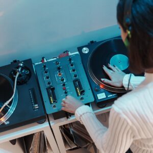 Female dj mixing tracks on professional turntable at event